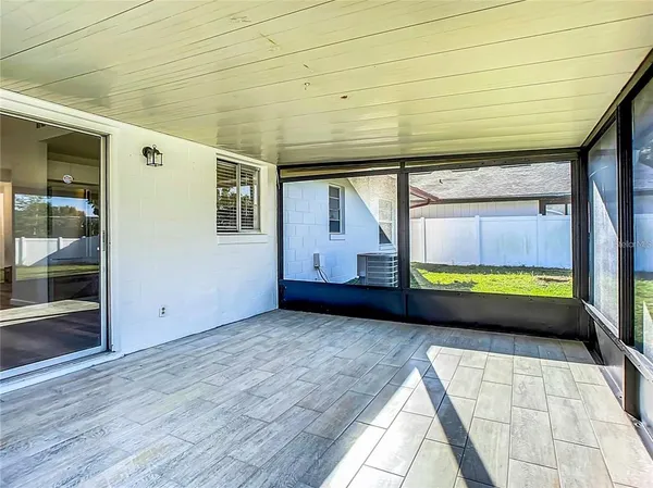 a view of an empty room with wooden floor and a floor to ceiling window