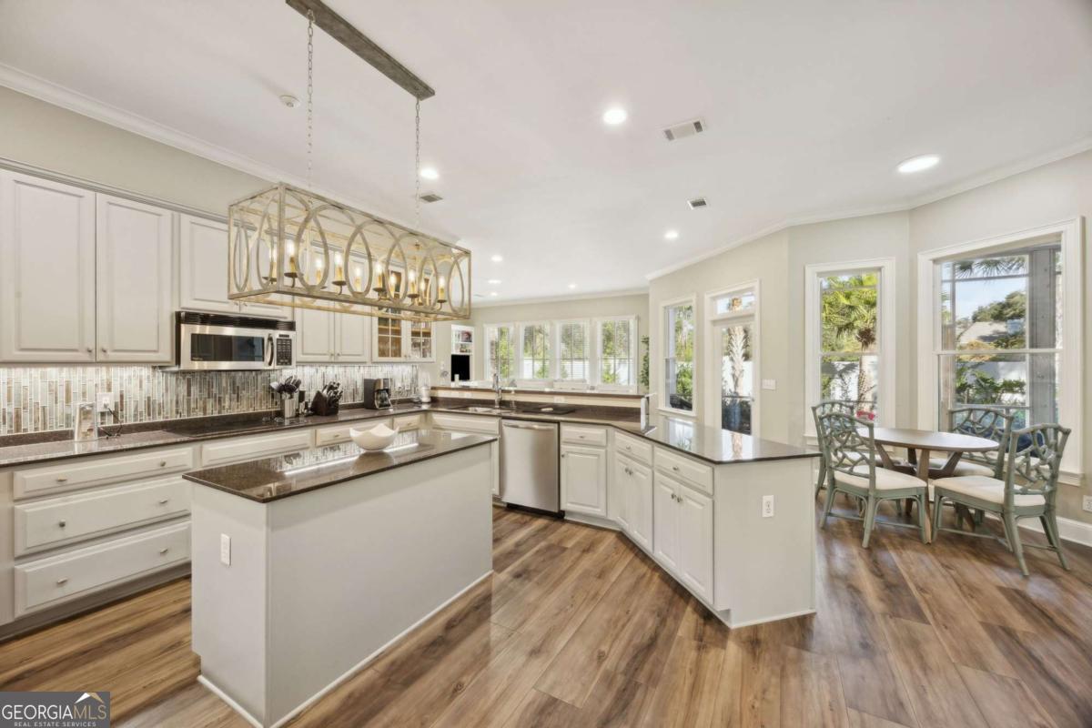 343 Major Wright Road St. Simons, GA 31522 - Photo 12 of 53 a kitchen with white cabinets appliances and wooden floor