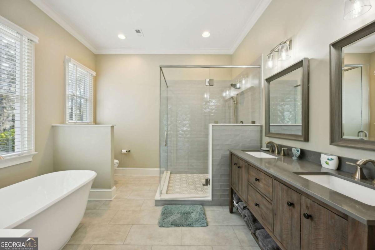 343 Major Wright Road St. Simons, GA 31522 - Photo 23 of 53 a bathroom with a granite countertop sink a toilet a mirror and shower