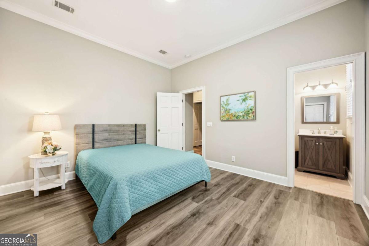 343 Major Wright Road St. Simons, GA 31522 - Photo 26 of 53 a bedroom with a bed and wooden floor