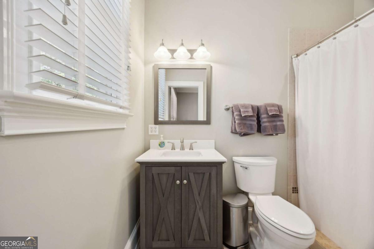 343 Major Wright Road St. Simons, GA 31522 - Photo 30 of 53 a bathroom with a toilet sink vanity and mirror