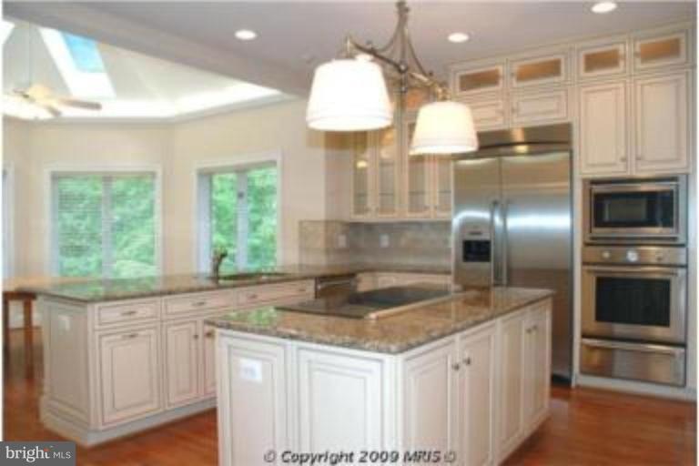 11008 South Glen Road Potomac, MD 20854 - Photo 5 of 12 a kitchen with granite countertop a sink stainless steel appliances and cabinets