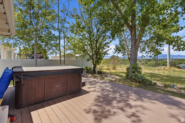 5788 Walden Ridge Drive Murray, UT 84123 - Photo 25 of 29 Spacious outdoor deck featuring a hot tub, composite decking, and mature trees
