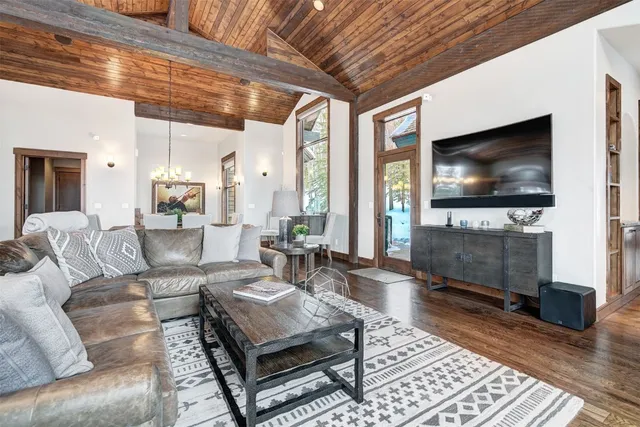 a living room with furniture a flat screen tv and a floor to ceiling window