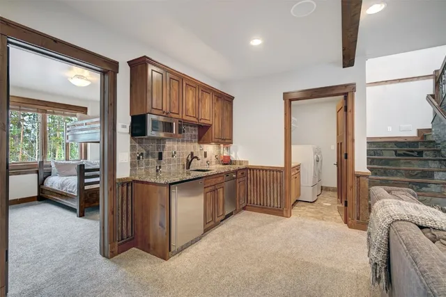 a kitchen with stainless steel appliances granite countertop a stove a sink and a refrigerator