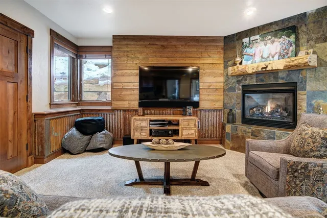 a living room with furniture a flat screen tv and a fireplace