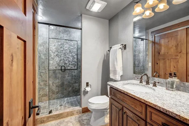 a bathroom with a granite countertop sink toilet and shower