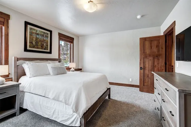 a bedroom with bed and paintings on the wall