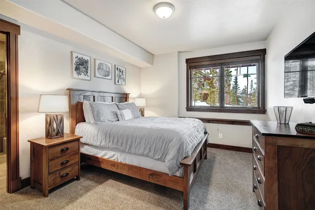 a bedroom with a bed and large windows