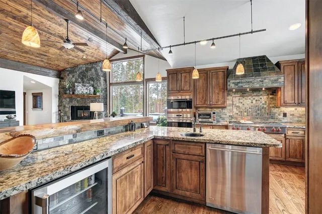 a kitchen with stainless steel appliances granite countertop a sink a stove and cabinets