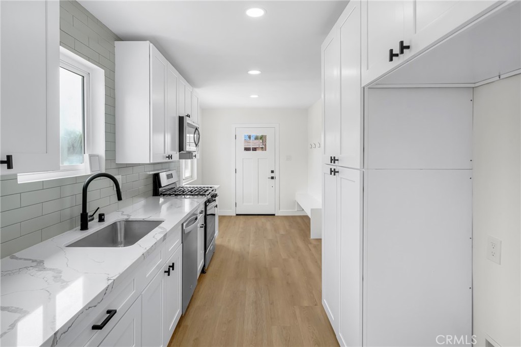 4713 Calada Avenue Pico Rivera, CA 90660 - Photo 7 of 24 a large white kitchen with a sink