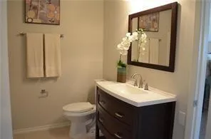 a bathroom with a toilet sink and mirror