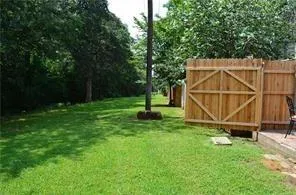 a view of backyard with a table and a wooden fence