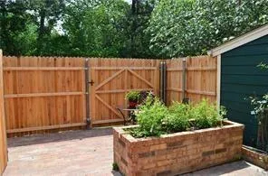 a wooden fence with some plants in the background