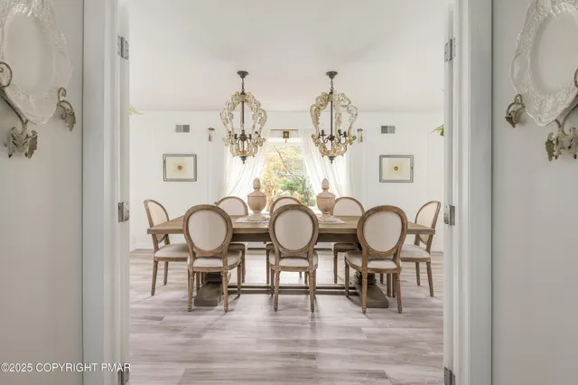 a view of a dining room with furniture a chandelier and wooden floor