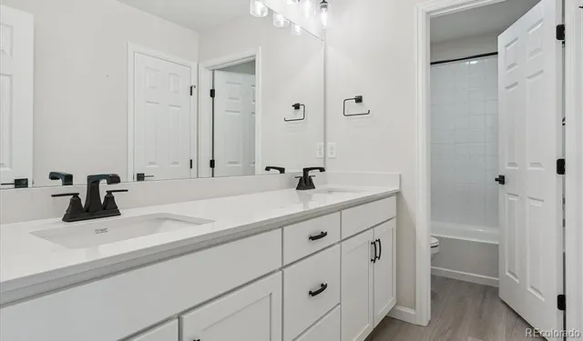 a bathroom with double vanity sink and a mirror