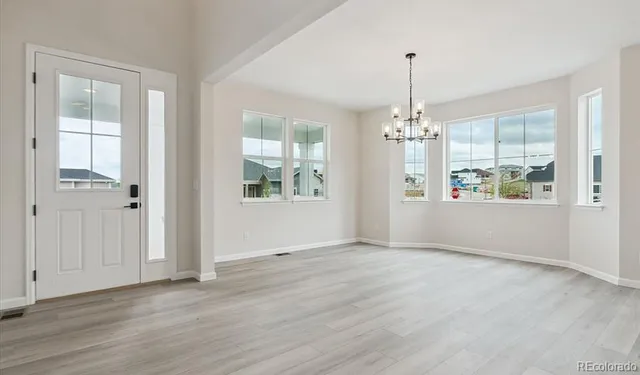 an empty room that has a window and wooden floor
