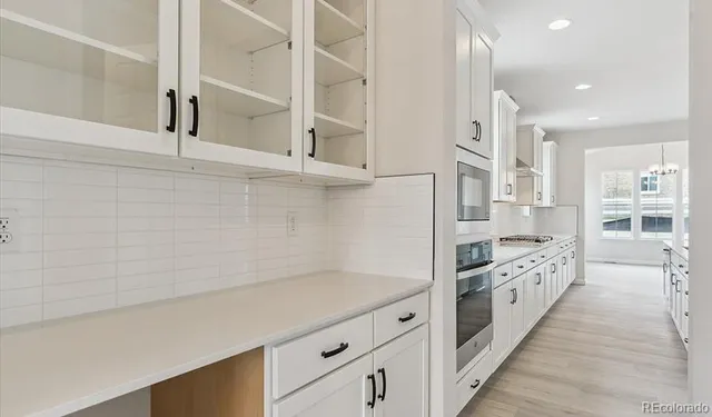a kitchen with white cabinets and white appliances