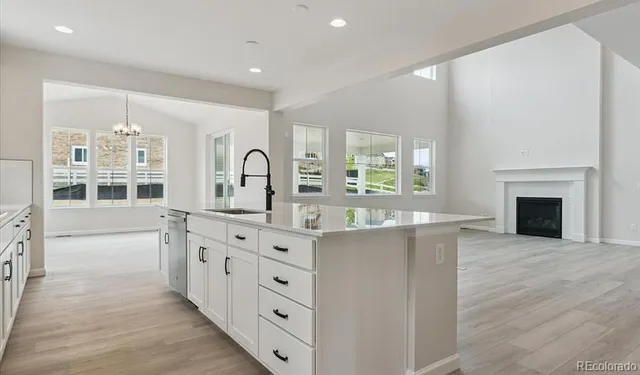 a large kitchen with stainless steel appliances a large counter top a sink and a window