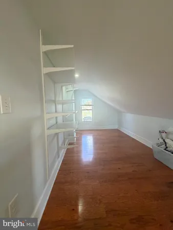 a view of a hallway with wooden floor and cabinet