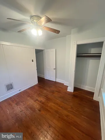 a view of empty room with wooden floor