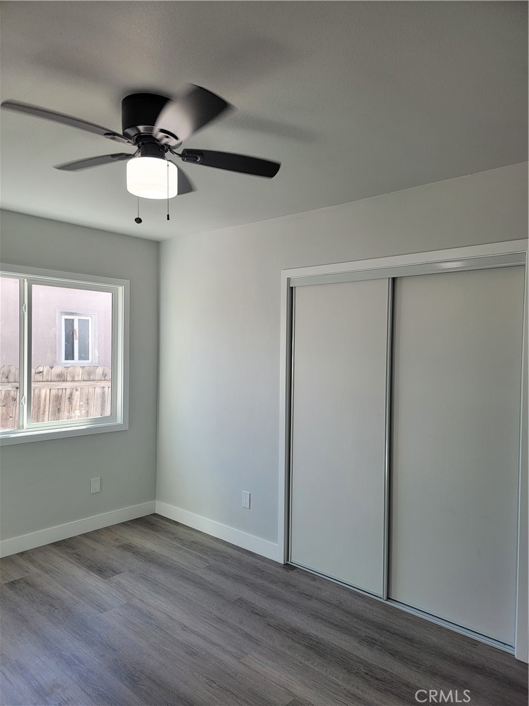 1637 Highland Street Santa Ana, CA 92703 - Photo 11 of 15 an empty room with wooden floor chandelier fan and windows
