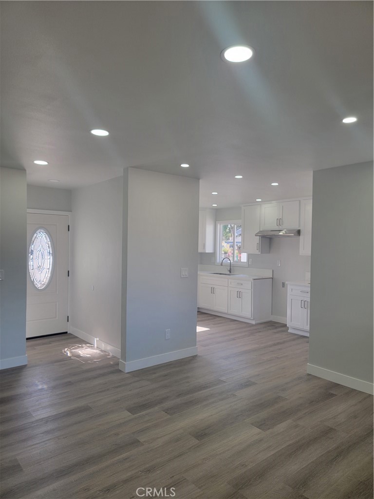 1637 Highland Street Santa Ana, CA 92703 - Photo 3 of 15 a view of an empty room and kitchen space with wooden floor
