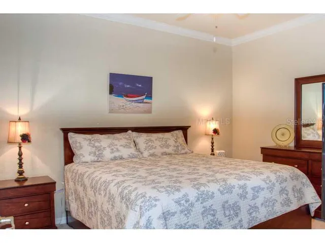 a bedroom with a bed and a lamp on dresser