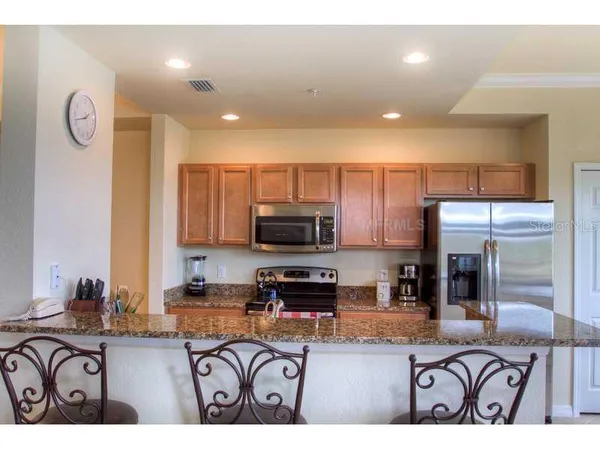a kitchen with stainless steel appliances granite countertop a refrigerator and a stove top oven