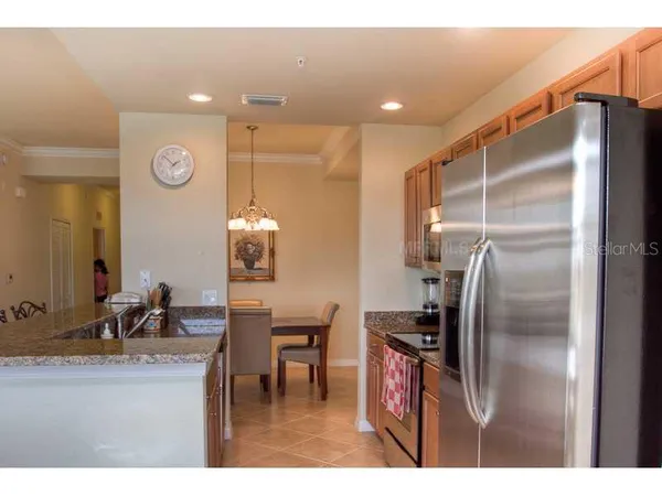a kitchen with stainless steel appliances granite countertop a sink refrigerator and cabinets