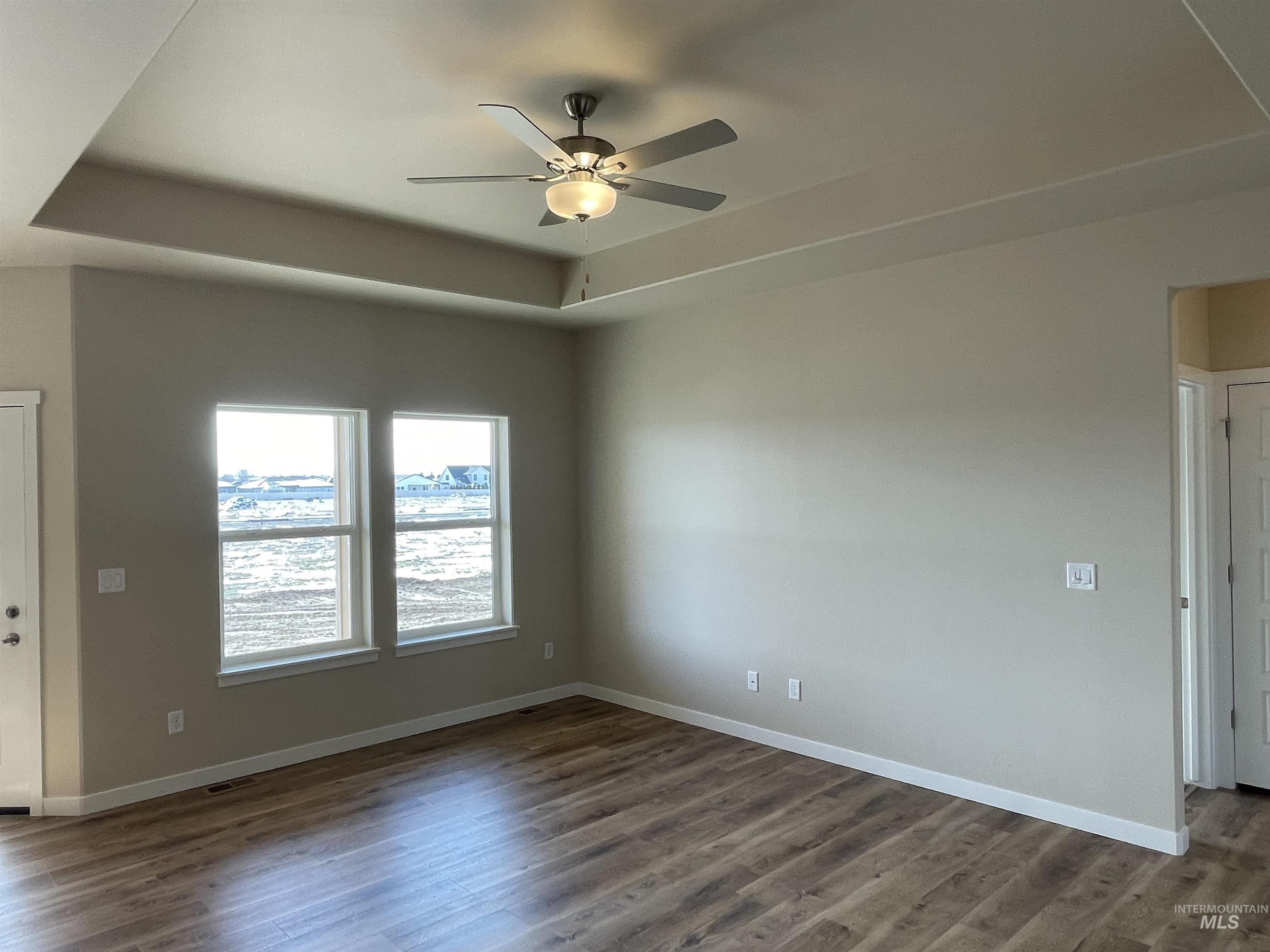 961 Quartz Road Kimberly, ID 83341 - Photo 5 of 19 Unfurnished room featuring a raised ceiling, dark wood-type flooring, and ceiling fan