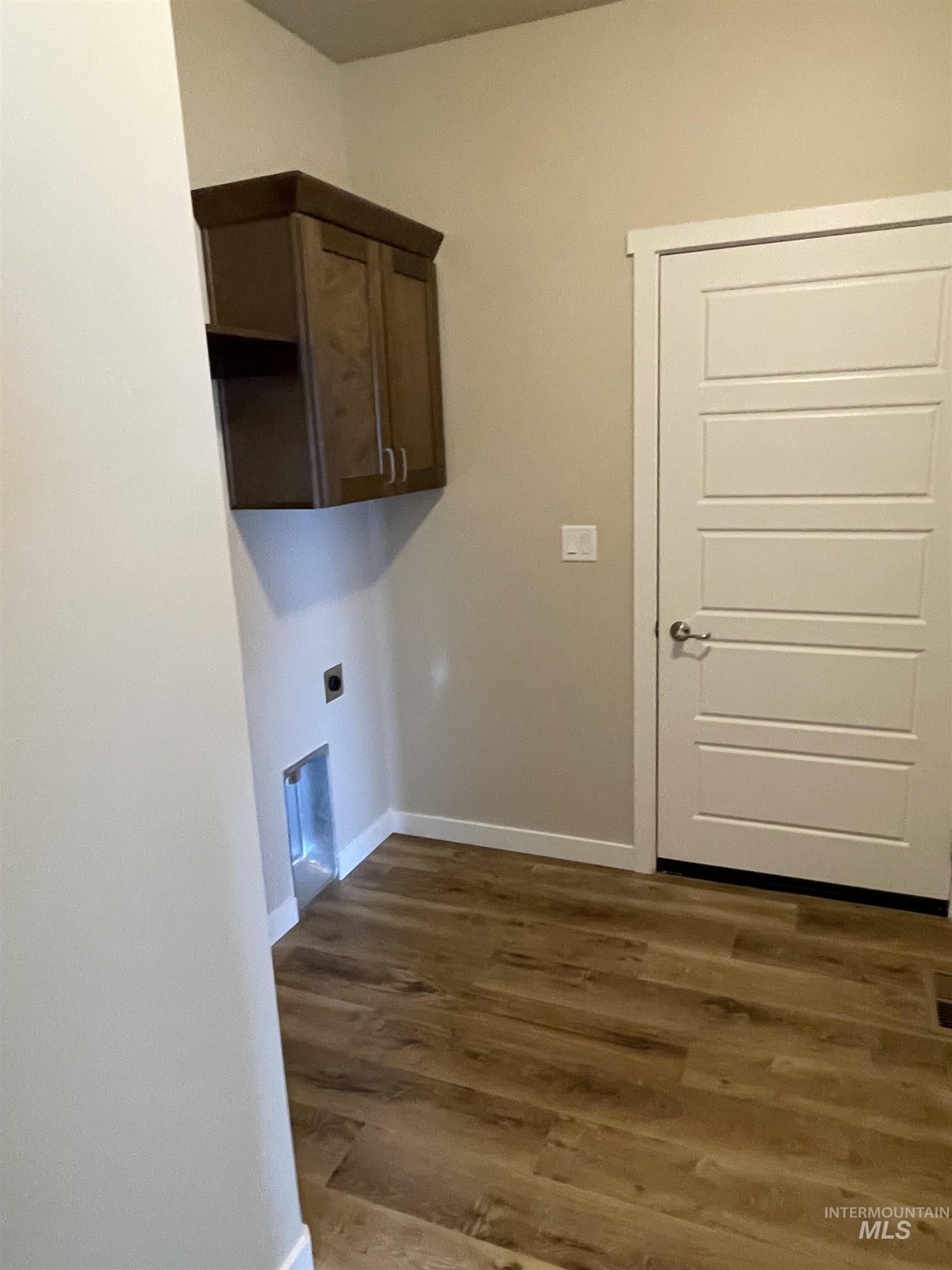 961 Quartz Road Kimberly, ID 83341 - Photo 6 of 19 Laundry area featuring dark wood-type flooring, electric dryer hookup, and cabinet space
