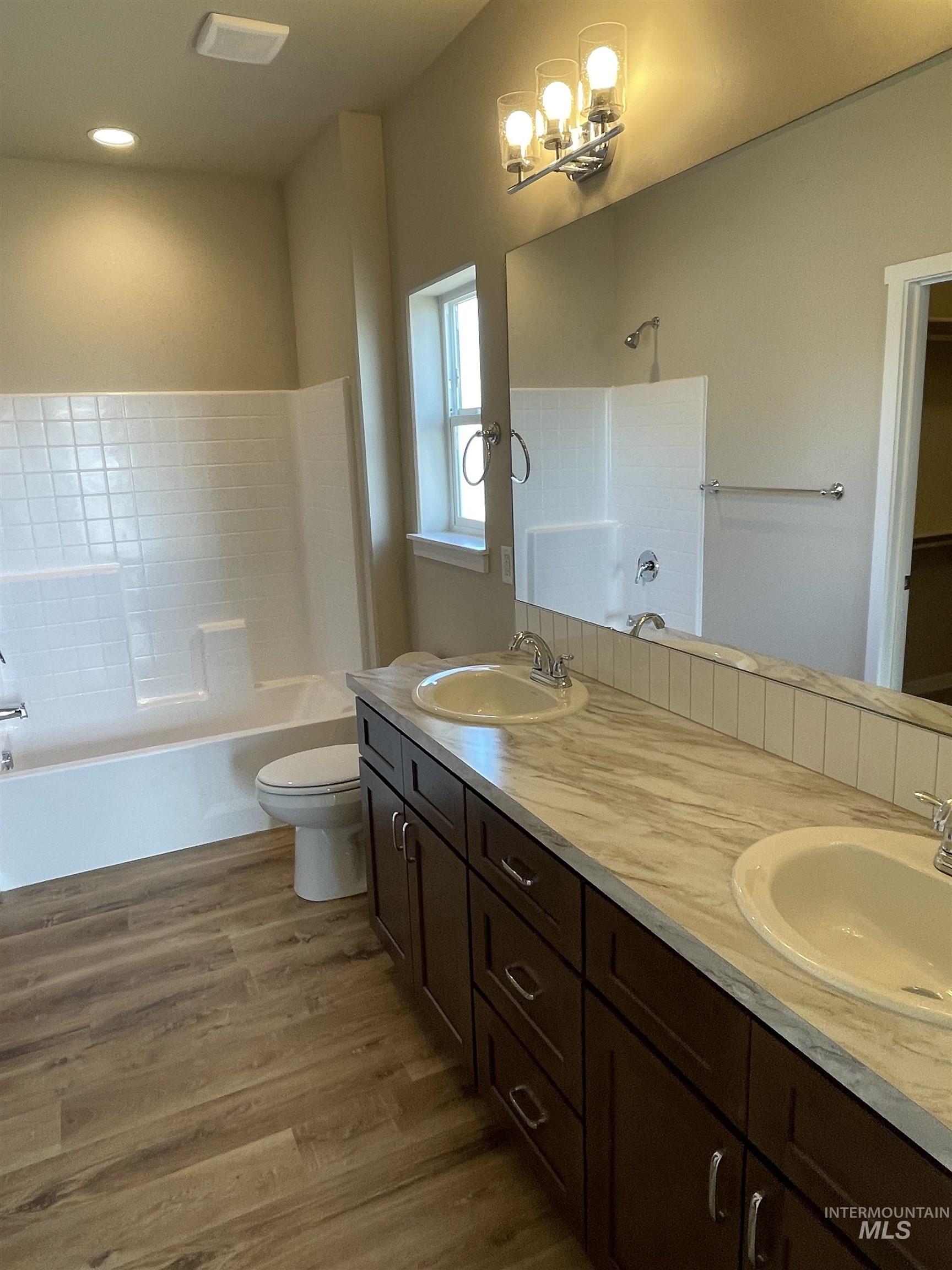 961 Quartz Road Kimberly, ID 83341 - Photo 8 of 19 Bathroom featuring double vanity, dark wood-type flooring, and shower / tub combination