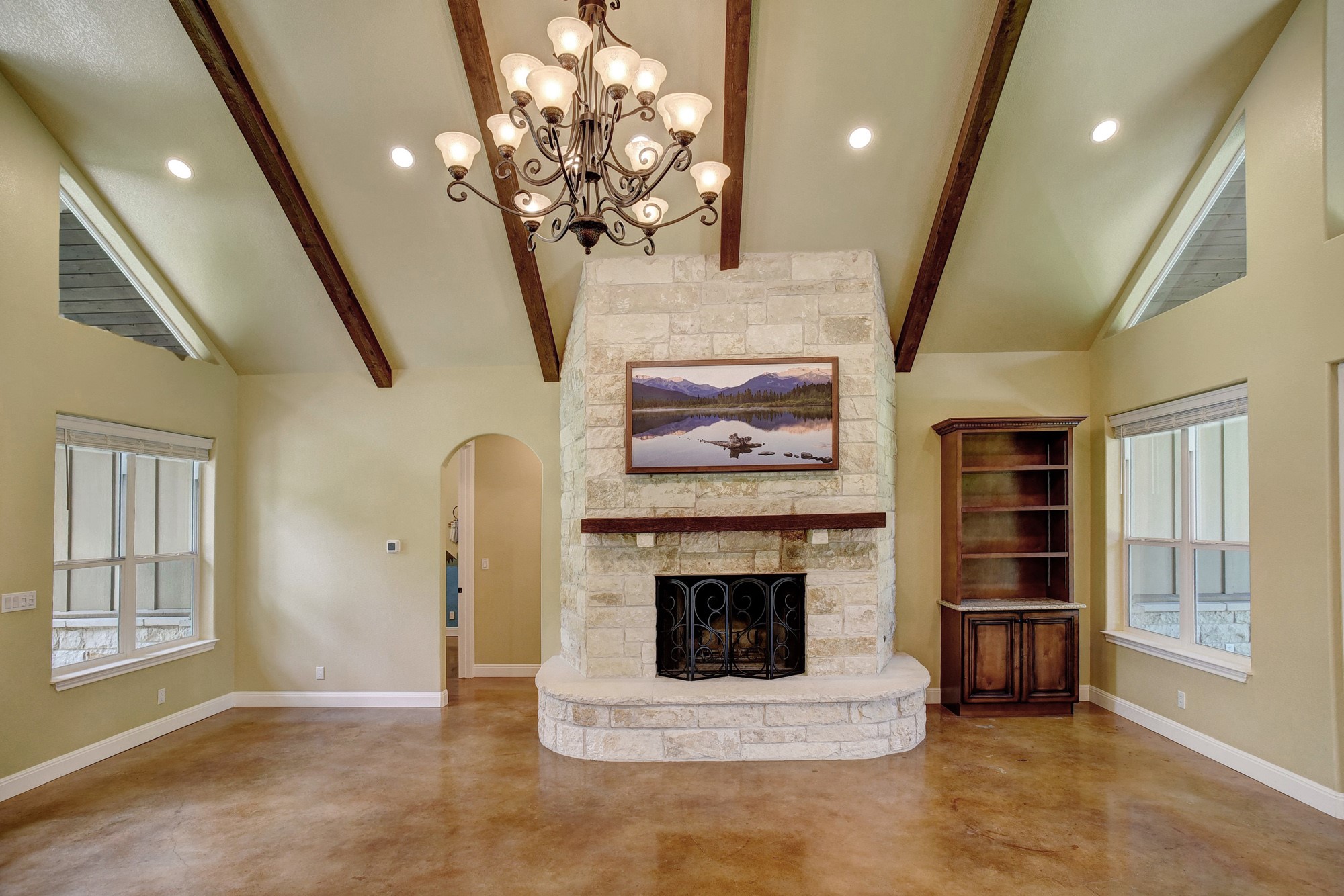 115 Pine Point Cove Elgin, TX 78621 - Photo 7 of 39 Architectural beamed ceilings create a captivating focal point in this living area, featuring a stone fireplace.