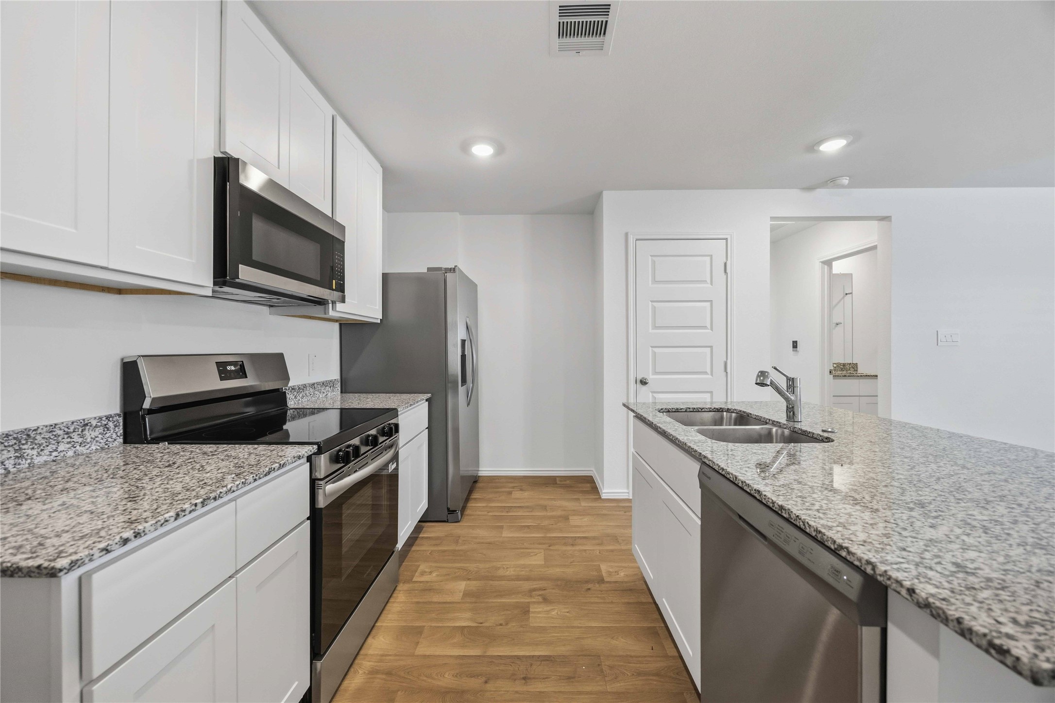 11908 Lilac Ice Lane Houston, TX 77048 - Photo 7 of 16 a kitchen with stainless steel appliances granite countertop a sink stove microwave refrigerator and cabinets