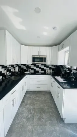 a large white kitchen with stainless steel appliances