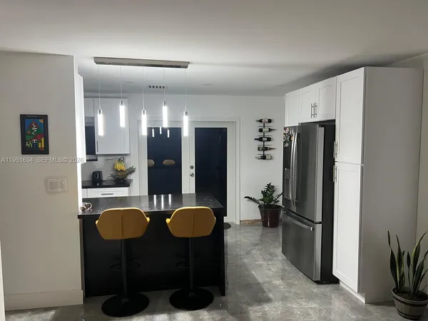 a view of kitchen with refrigerator and sink