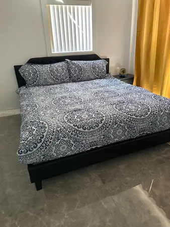 a bed sitting in a bedroom next to a window