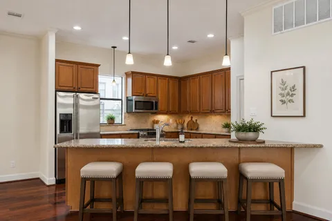 a kitchen with kitchen island granite countertop a sink and refrigerator