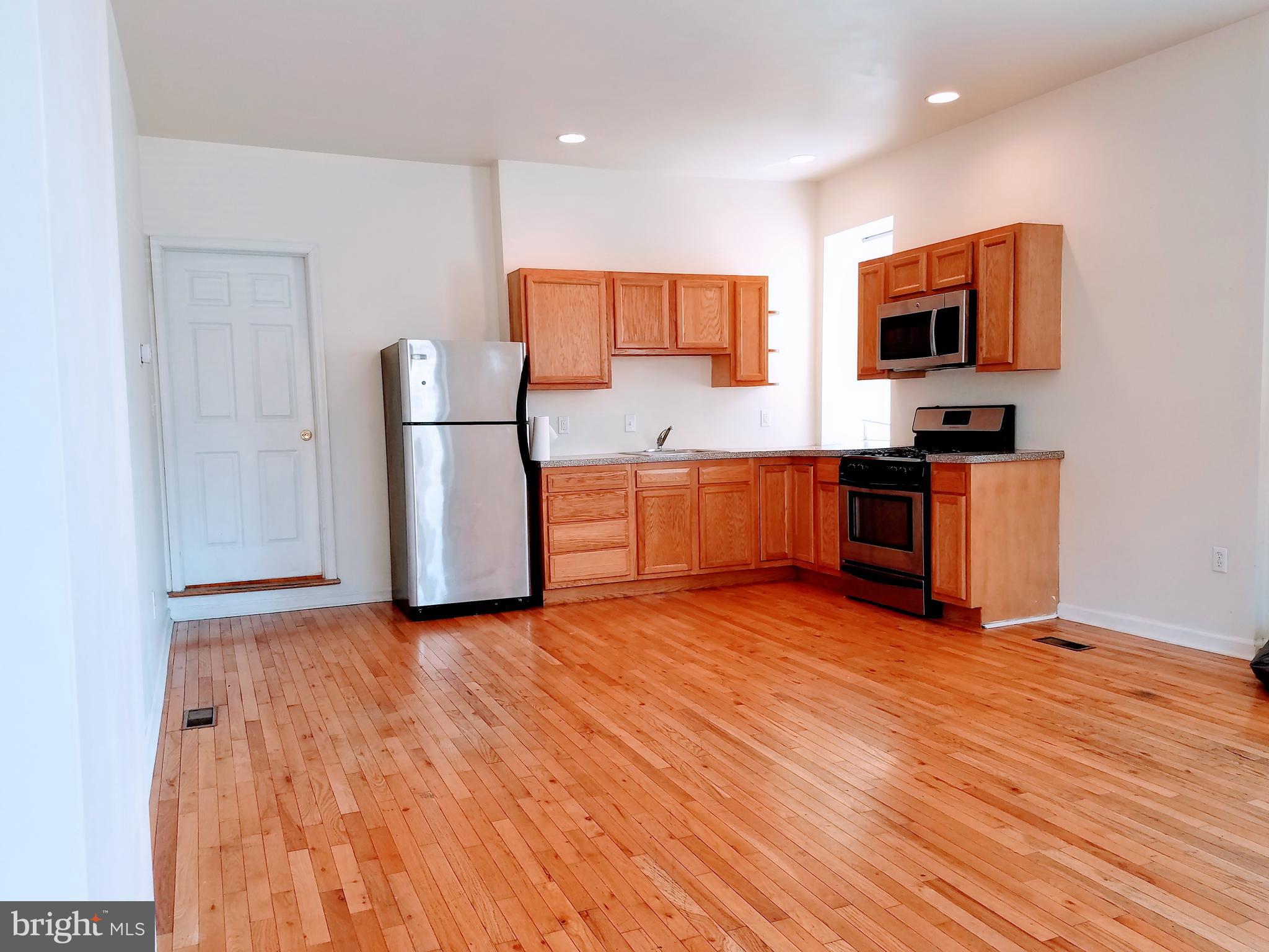 1951 South 4th Street, Unit 1 Philadelphia, PA 19148 - Photo 1 of 8 a kitchen with stainless steel appliances granite countertop a stove a sink and a refrigerator
