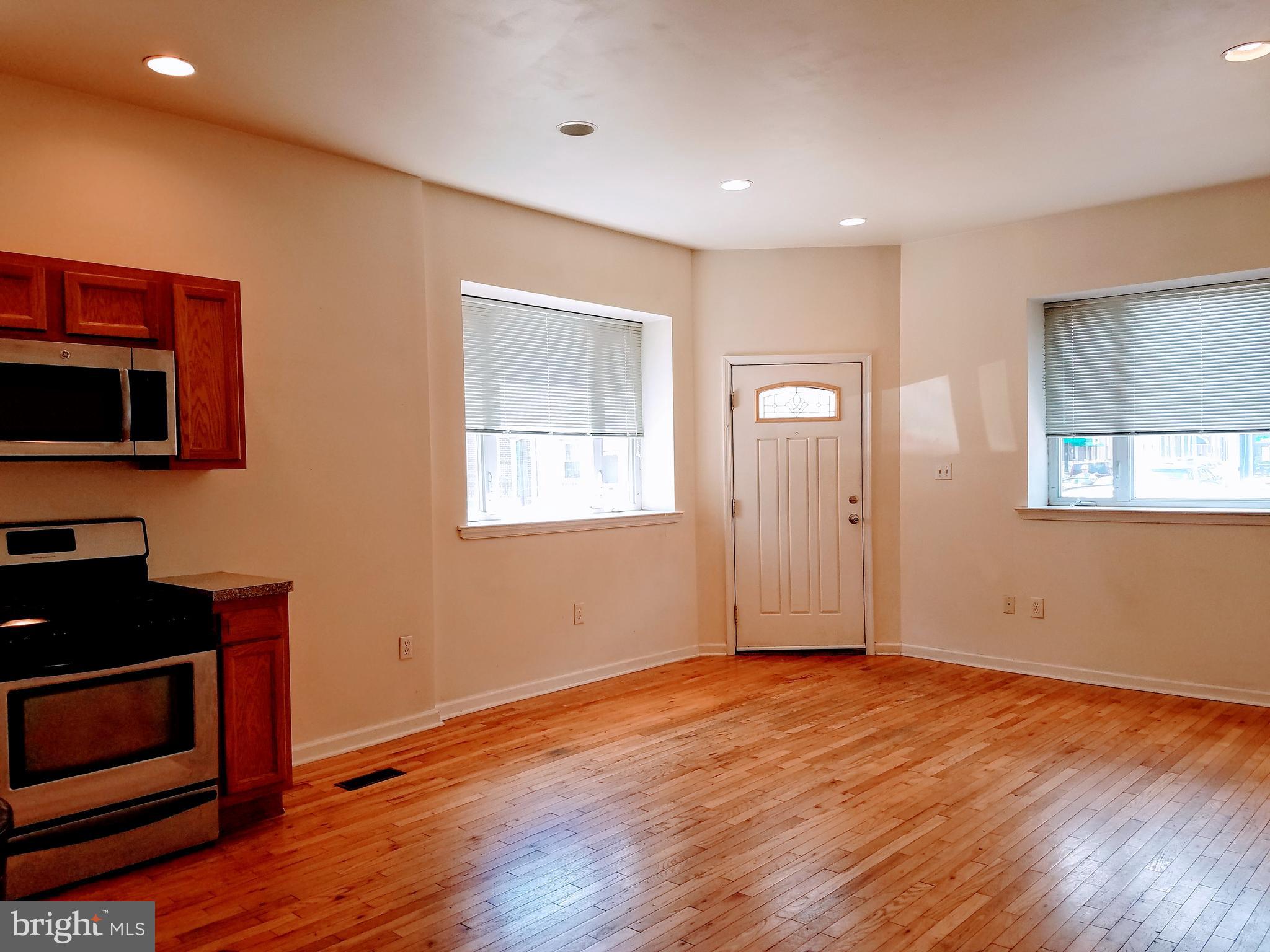 1951 South 4th Street, Unit 1 Philadelphia, PA 19148 - Photo 2 of 8 a view of an empty room with wooden floor and a window