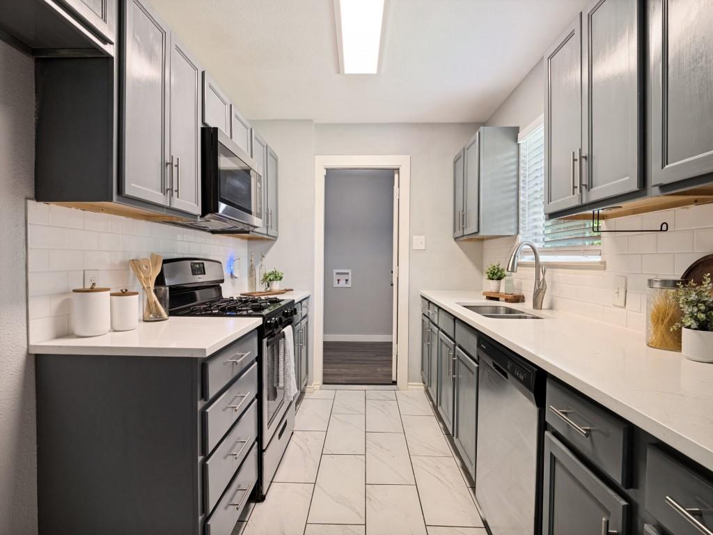 1405 Rambler Road Arlington, TX 76014 - Photo 11 of 26 Galley kitchen featuring gray cabinetry, white countertops, stainless steel appliances, white subway tile backsplash, and large format tile flooring