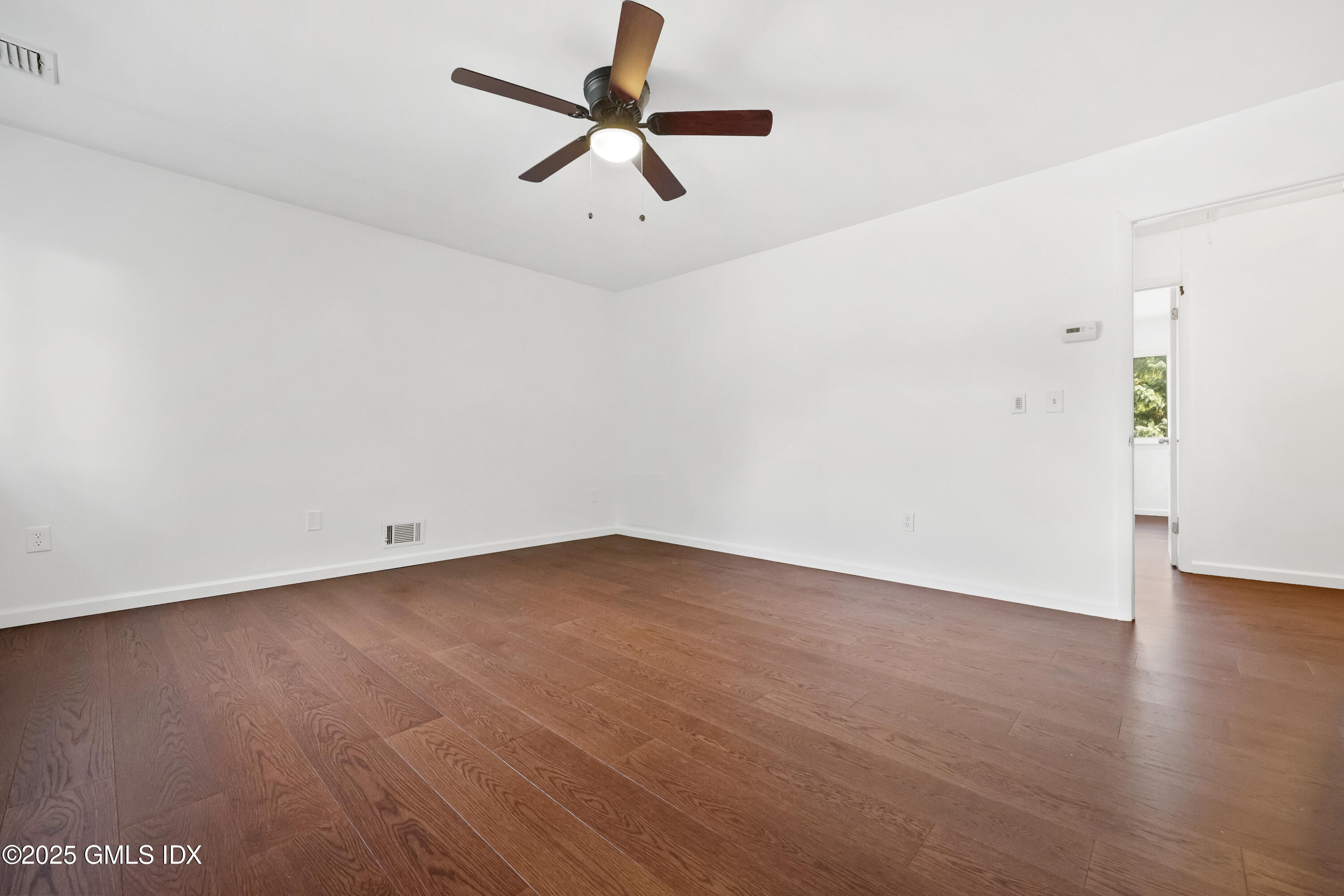 75 Cos Cob Avenue, Unit 14 Cos Cob, CT 06807 - Photo 11 of 28 an empty room with wooden floor ceiling fan and windows