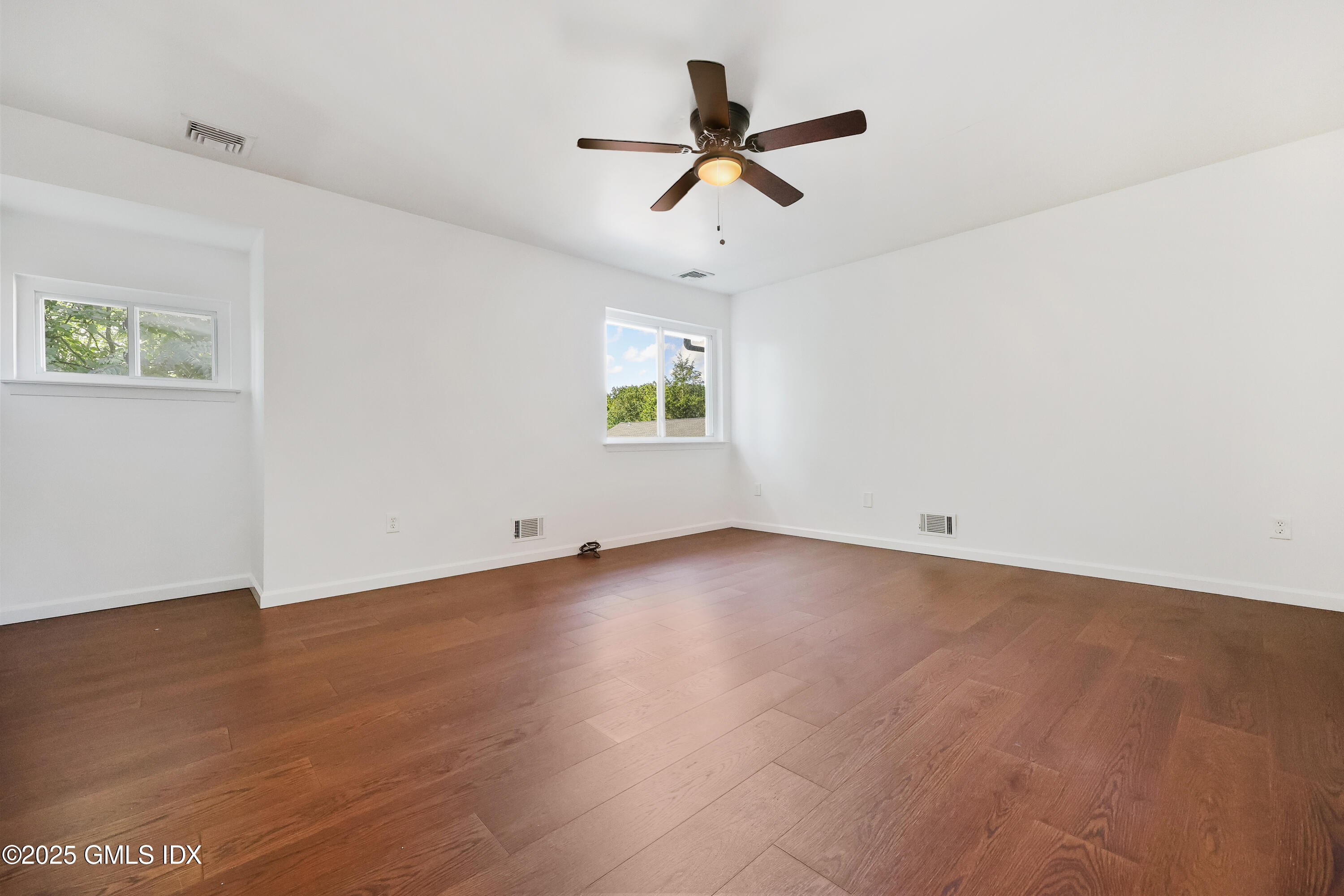 75 Cos Cob Avenue, Unit 14 Cos Cob, CT 06807 - Photo 14 of 28 an empty room with wooden floor ceiling fan and windows