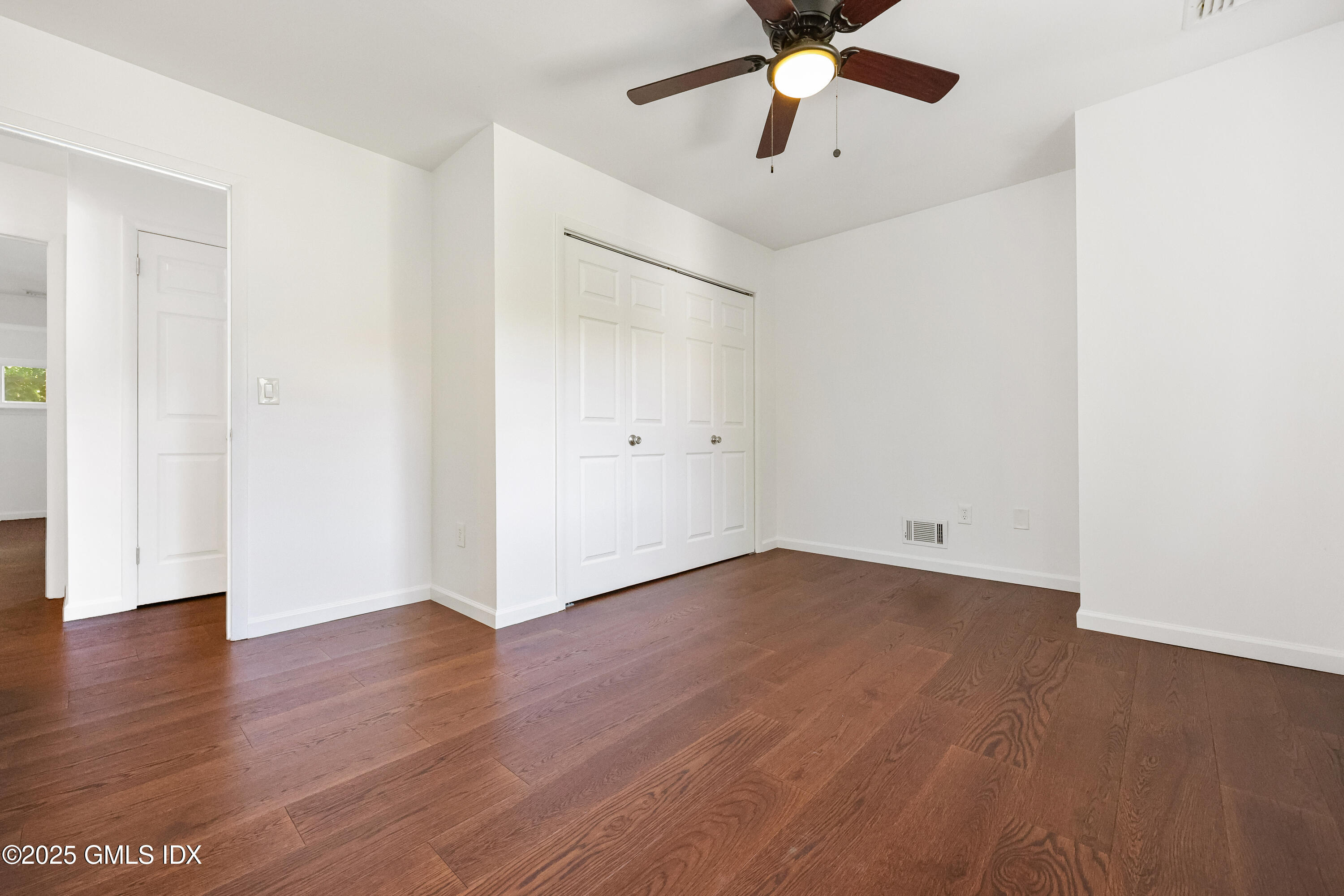 75 Cos Cob Avenue, Unit 14 Cos Cob, CT 06807 - Photo 17 of 28 an empty room with wooden floor chandelier fan and windows