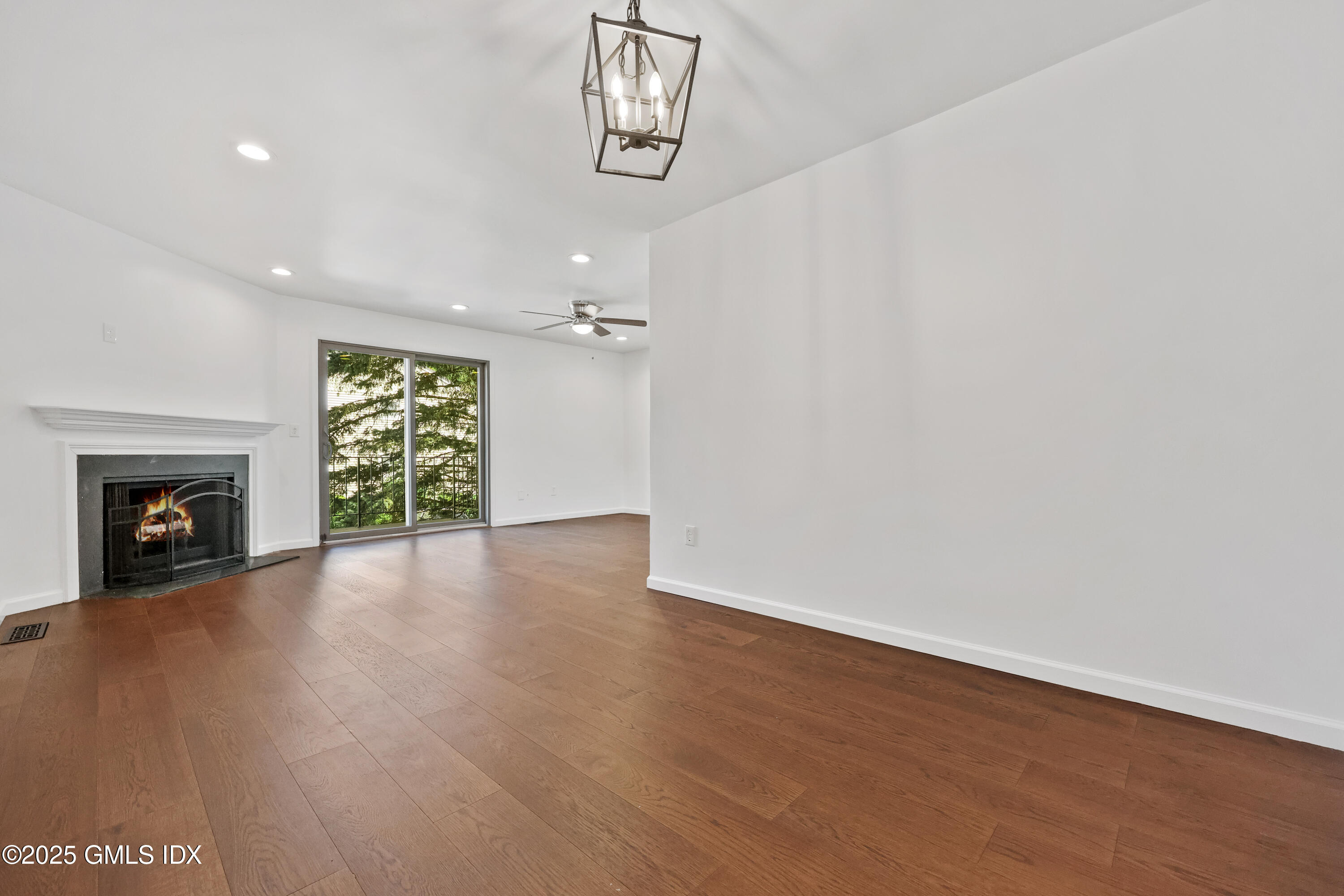 75 Cos Cob Avenue, Unit 14 Cos Cob, CT 06807 - Photo 5 of 28 an empty room with windows and fireplace