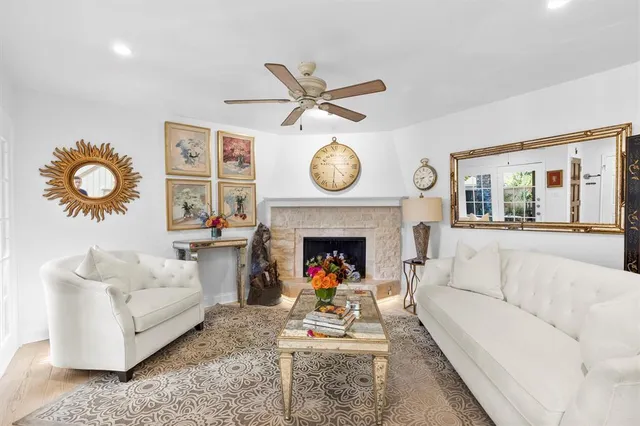 a living room with furniture a clock and a fireplace
