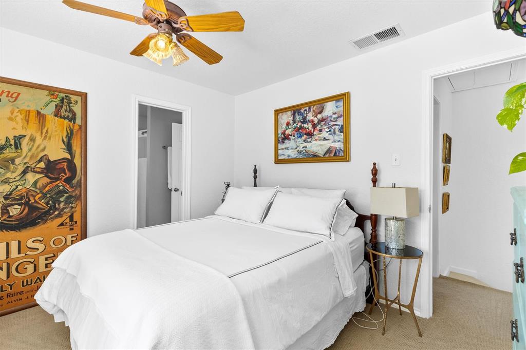 5200 Martel Avenue, Unit 32B Dallas, TX 75206 - Photo 18 of 35 a bedroom with a bed and a chandelier