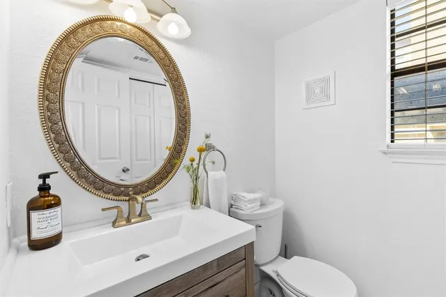 a bathroom with a sink mirror and toilet