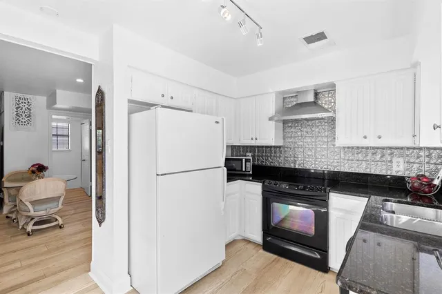a kitchen with a refrigerator and a stove top oven